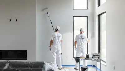 Professional interior painters finishing historic Philadelphia PA living room walls with smooth color finish